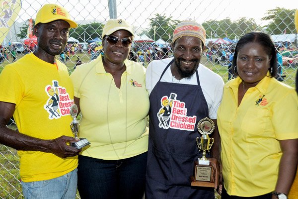 Rudolph Brown/Photographer
Heather Collins, (right) Sales Manager of Best Dressed and Cordia Panton-Williams, pose with winners Malik Martin, (second right) 1st place winner of Royal Maroon and 2nd runner up David Graham pose with winning trophy at the Best Dressed Chicken Portland Jerk Festival at Folly Ruins in Portland on Sunday, July 7, 2013