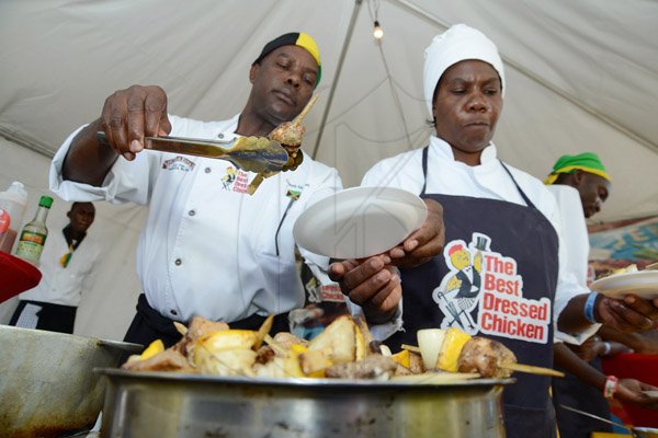 Rudolph Brown/Photographer
Chef Dennis McIntosh, (left) with chef Sharon Byfield serve jerk chicken Kebabs with vegetables at the Best Dressed Chicken Portland Jerk Festival at Folly Ruins in Portland on Sunday, July 7, 2013