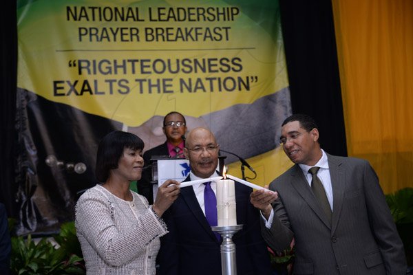 Jermaine Barnaby/Photographer
Prime Minister Portia Simpson Miller (left) and Opposition Leader Andrew Holness jointly light a candle as a symbol for national unity at the annual National Leadership Prayer Breakfast at the  Jamaica Pegasus Hotel in New Kingston on Thursday, January 21, 2016. At center is His Excellency, Governor-General Sir Patrick Allen.