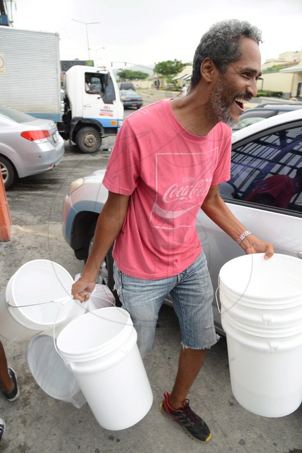 Rudolph Brown/PhotographerThis man leaving with his buckets he buy from the Super Valu Home Centre in Liguanea in preparation for Hurricane Matthew on Saturday, October 1, 2016