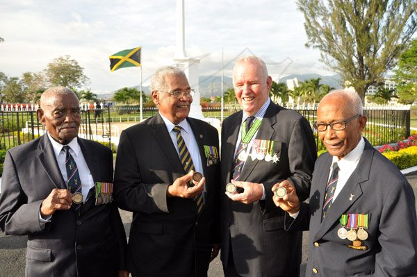 Jermaine Barnaby/Photographer
World war 11 veteran Major Victor Beek, Colonel Torrance Lewis, Major General Robert Neish and Barry Beckford shows off a coin they received from US President Barrack Obama just before he laid a wreath at National Heroes Park on Thursday April 9, 2015.