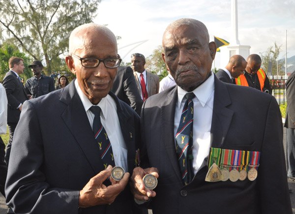 Jermaine Barnaby/Photographer
World war 11 veterans Barry Beckford (left) and major Victor Beek shows off coins they received from US President Barrack Obama just before he laid a wreath at National Heroes Park on Thursday April 9, 2015.