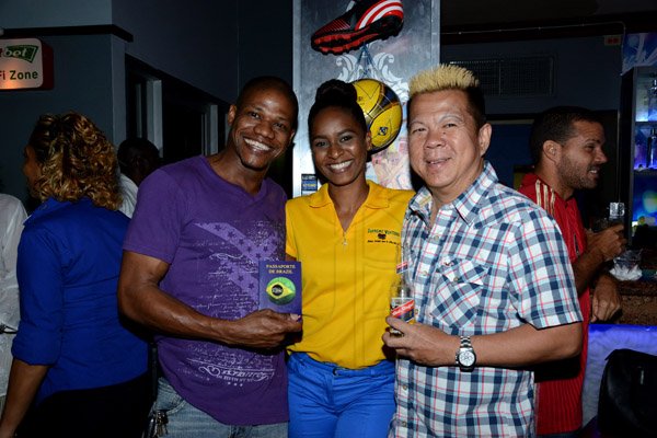Winston Sill/Freelance Photographer
Ribbiz Ultra Lounge host the Grand Unveiling of World Cup Viewing Party, held at Batbican Centre, East King's House Road on Wednesday night June 11, 2014. Here Mark Gibbs (left) is all smiles after collecting his Ribbiz Footbal Passport from Shavelle Mayler (centre), Abministrative Assistant, Supreme Ventures; and Brian Chung (right). The Passport allows free access to all World Cup Football Viewing events at Ribbiz.