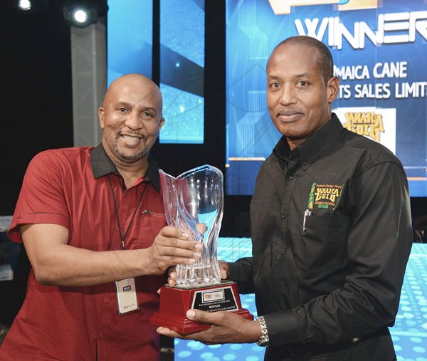 Jermaine Barnaby/ Freelance Photographer<\n>Major Hugh Blake (right) collects the top spending advertiser award for Power 106 from Colin Hines at the RJRGLEANER CLIENT APPRECIATION AWARDS at the Sunken Gardens at Hope Botanical Gardens on Thursday, June 22, 2017. *** Local Caption *** @Normal:Major Hugh Blake (right) from Jamaica Cane Products Sales Ltd collects the Top Spending Advertiser Award for Power 106 and Music 99 FM from Colin Hines.