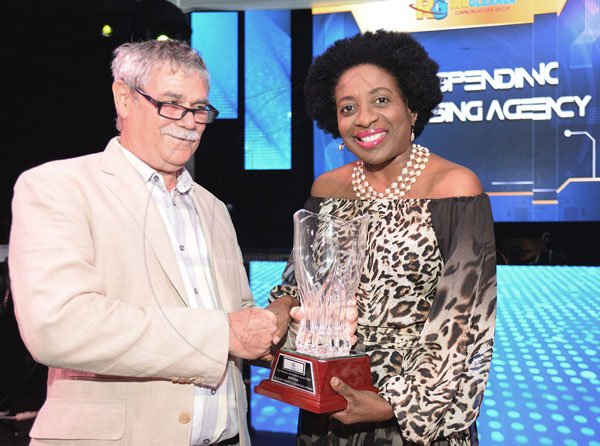 Jermaine Barnaby/ Freelance Photographer<\n>Wayne Stewart (left) accepting the top spending advertising agency award for Gleaner from Janet Silvera during the RJRGLEANER CLIENT APPRECIATION AWARDS at the Sunken Gardens at Hope Botanical Gardens on Thursday, June 22, 2017. *** Local Caption *** @Normal:Wayne Stewart (left) from Dunlop Corbin Communications accepting Top Spending Advertising Agency Award from Janet Silvera.