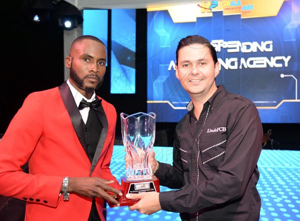 Jermaine Barnaby/ Freelance PhotographerSean Duquesnay (right) accepting the top spending advertising agency award for Go Jamaica from Teino Evans during the RJRGLEANER CLIENT APPRECIATION AWARDS at the Sunken Gardens at Hope Botanical Gardens on Thursday, June 22, 2017.