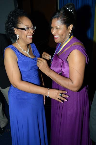 Rudolph Brown/ Photographer
Outgoing President  of the Rotary Club of St Andrew Judy Hylton, (right) pin new president Marie Powell after she was installed at the club Installation banquet at the Jamaica Pegasus Hotel in New Kingston on Tuesday, July 9, 2013.