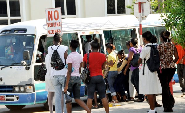 Norman Grindley / Staff Photographer
Commuters board a bus at the intersection of Tower and King Street downtown Kingston after business comes to a halt in the city early yesterday afternoon.