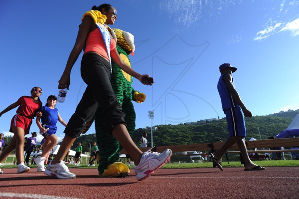 Ricardo Makyn/Staff Photographer
Miss Jamaica World Deanne Williams with the Reggae Tiger  at the Heart Fund run titled Run for your Heart at the Stadium  East Track on Sunday 25.11.2012