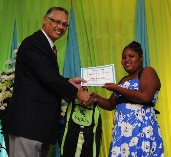 Ricardo Makyn/Staff Photographer
Errol McKenzie Executive Vice President Sagicor presents Ashanae Aris who will be attending St Mary High School   at the Sagicor annual GSAT awards ceremony at the Knutsford Court Hotel on Thursday 23.8.2012