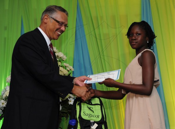 Ricardo Makyn/Staff Photographer
Errol McKenzie Executive Vice President Sagicor presents Alana Anaje who will be attending Westwood High School   at the Sagicor annual GSAT awards ceremony at the Knutsford Court Hotel on Thursday 23.8.2012