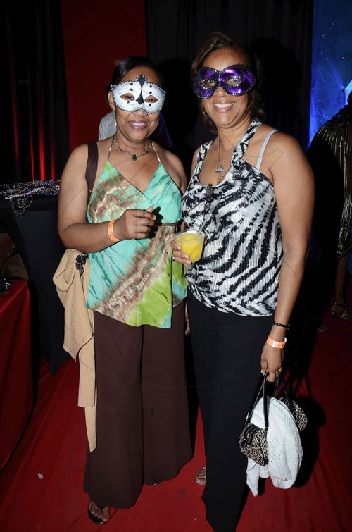 Rudolph Brown/Photographer
Jennifer Williams (left) and Annette Rainford try too hide behind their masks at the Sagicor Christmas party at the office car park in New Kingston on Saturday night.

*****************************************************************************, December 3-2011