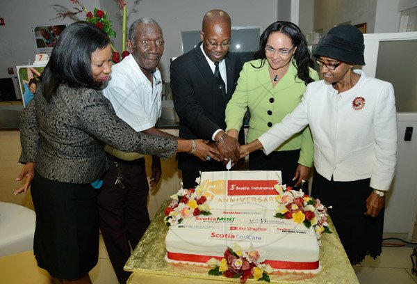 Rudolph Brown/Photographer
Bisness Desk
Hugh Reid, (centre) President of Scotia Insurance cutting cake with from left Lana Forbes, Duncan Elvin, Dahlia Dawkins and Kay Clunis at the Scotia Insurance 15th Anniversary branch forum at the Constant spring branch on Thursday, June 27, 2013