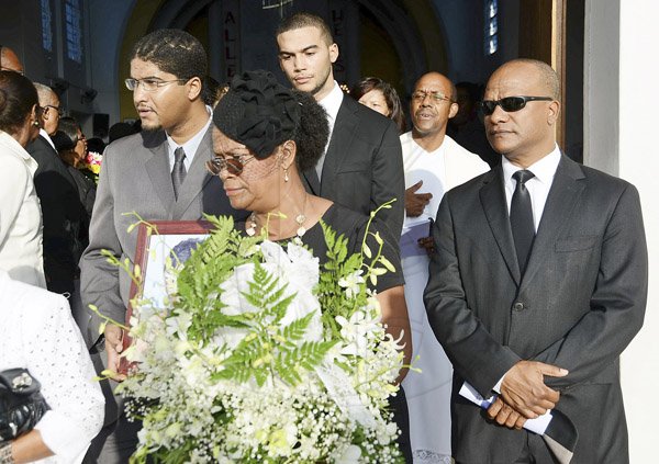 Rudolph Brown/Photographer
Charmaine Thompson, (centre) carry the urn of her mother along with  Minister Peter Bunting, (right) and grandsons St. John Bunting, (second left) and Brent Bunting, (second right) after the funeral service for the late Pauline Bunting, Minister Peter Bunting mother at Sts. Peter and Paul Catholic Church on Monday, April 22, 2013