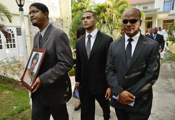 Rudolph Brown/Photographer
Minister Peter Bunting, (right) and the grandsons of his mother St. John Bunting, (left) and Brent Bunting, carry the photo after the funeral service for the late Pauline Bunting, Minister Peter Bunting mother at Sts. Peter and Paul Catholic Church on Monday, April 22, 2013