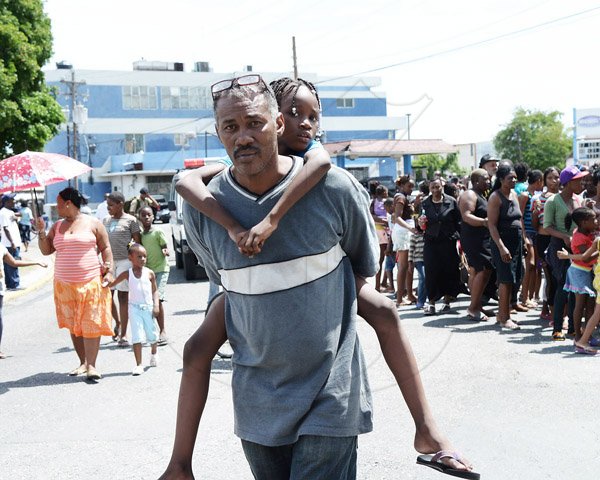 Ian Allen/Staff Photographer

This little girl got a piggyback ride yesterday at the National Heroes Circle as onlookers rush to view the Funeral Procession for the late Governor General Sir Howard Cooke. He was buried at the National Heroes Park.