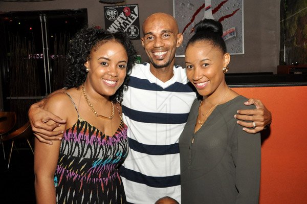 Jermaine Barnaby/Photographer
Cary Munoz  (center) is sandwiched by his wife Terese Heron-Munoz (left) and Yazmin Heron as they dined during RW Something Blue Challenge at usain bolt's tracks and records on Tuesday, November 18, 2014.