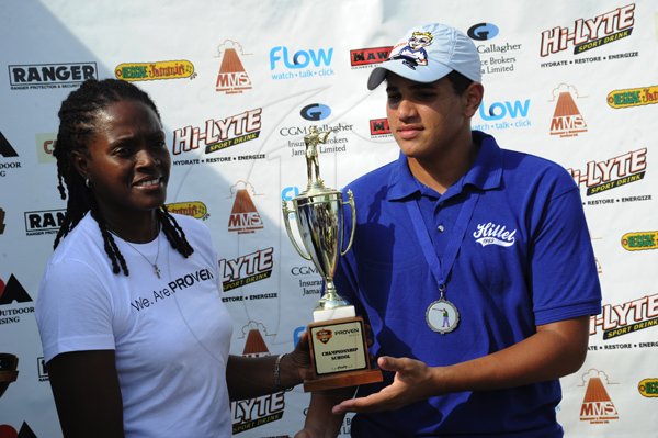 Norman Grindley/Chief Photographer
President of Proven Wealth Chorvelle Johnson (left) presents the championship school trophy to Chad Ziadie, captain of Hillel Academy at ClayFeva, first event of the Proven  SportsFeva 2012, held at the Jamaica Skeet club in Portmore, St Catherine November 4, 2012.