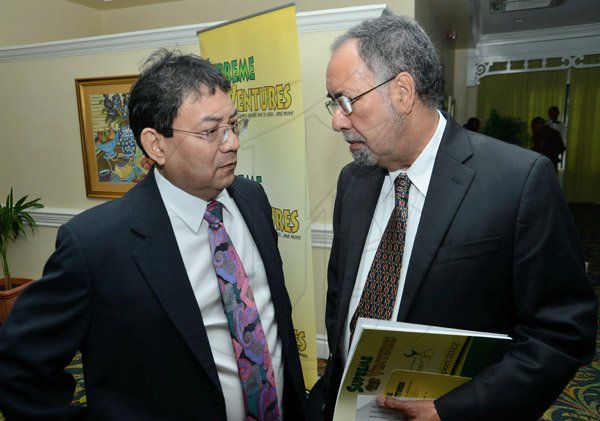 Rudolph Brown/Photographer
Paul Hoo, (centre) Chairman looking at the annual report with Brian George,(left) President and CEO and Ian Levy, (right) Board Director at the Supreme Ventures Ltd AGM at Knutsford Court Hotel in Kingston on Monday, June 3, 2013