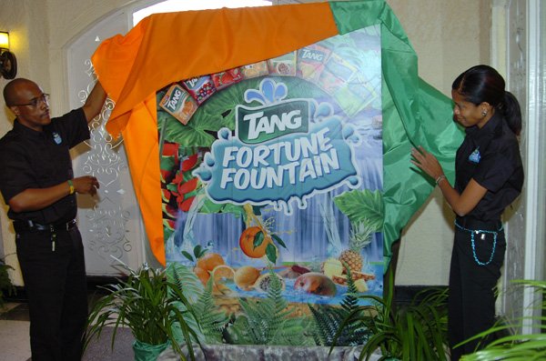 Rudolph Brown/Photographer
Pernal Elliston, Business Development Manager of Kraft Foods and Melissa Bennett, Brand Manager of Kraft Foods unveiling the Tang Fortune Fountain at the Tang Outreach press conference to launch the Tang Fortune Fountain at the Terra Nova Hotel in Kingston on Tuesday, August 28-2012