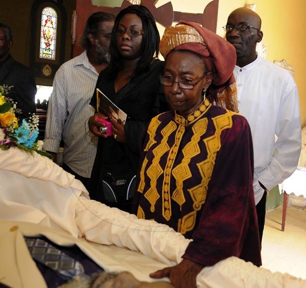 Gladstone Taylor  / Photographer

Flo O' Connor Pays her respects to Philip Burrell while Basil Hylton (right) and Audrey Burrell (left) looks on

Thanksgiving Service for the life of Philip "Fattis" Burrell held at the Holy Trinity Cathedral, 1-3 George Headley Drive, Kingston on Saturday December 17, 2011