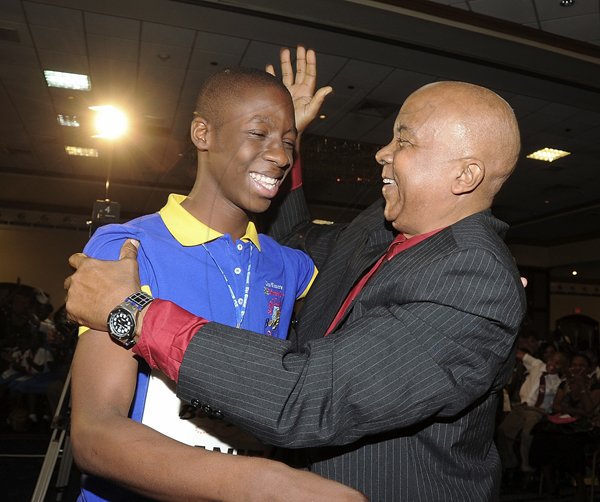 Ian Allen/Photographer
Well done, my boy! Hanif Brown (left) The Gleaner's Children's Own Spelling Bee champion for 2011 gets a hug and a well-deserved pat on the back from  his coach, the Reverend Glen Archer after winning the competition on Wednesday at The Jamaica Pegasus hotel in New Kingston.
