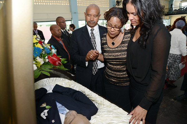 Rudolph Brown/Photographer
From left are Dr Gene Archer Marcia Archer-Groves and Giselle Groves family members view the body of Rev. Glen Archer at the Thanksgiving service for the life Rev Glen Archer at the Ardenne High School Auditorium in Kingston on Sunday, March 1, 2015