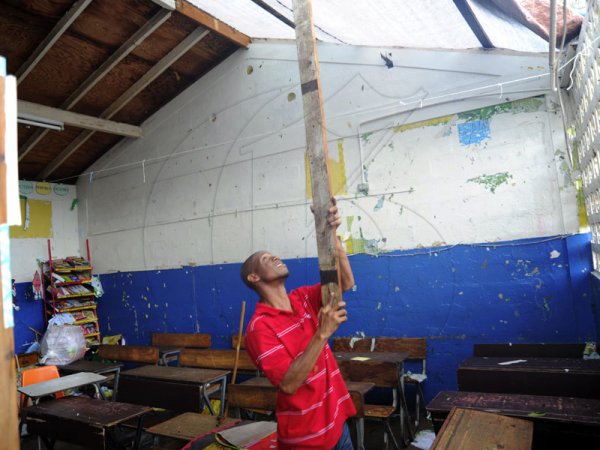 Norman Grindley/Chief Photographer
Principal at the Swallowfield primary and Junior high school in St. Andrew tries to get this class room ready after the roof was blown off by hurricane Sandy.