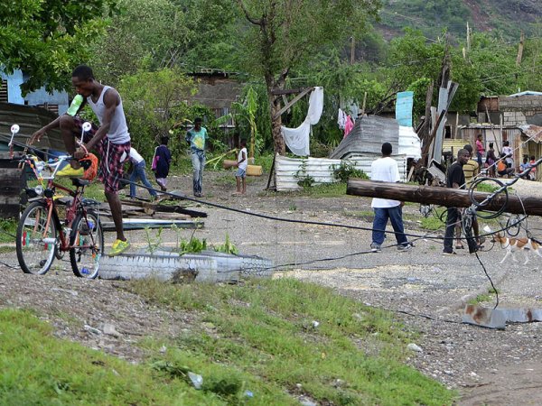 Ian Allen/Photographer
Residents of Taylor Land in Bull Bay St.Andrew maneuver around a Jamaica Public Service utility pole which was blown down during the passage of Hurricane Sandy.