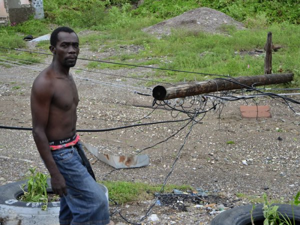 Ian Allen/Photographer
A resident of Taylor Land in Bull Bay St.Andrew maneuver around a Jamaica Public Service utility pole which was blown down during the passage of Hurricane Sandy.