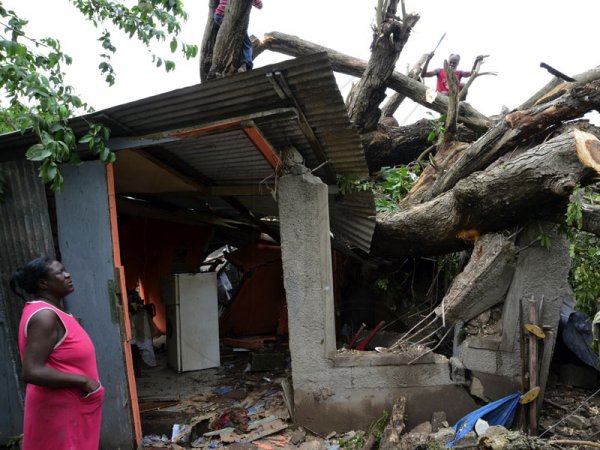 Rudolph Brown/Photographer
Angela Forbes looks at the remains of her house, as men try cutting the guango tree that fell on her dwelling in Clifton in St. Catherine.

Hurricane Sandy passes through Jamaica on damage properties on Thursday, October 25, 2012