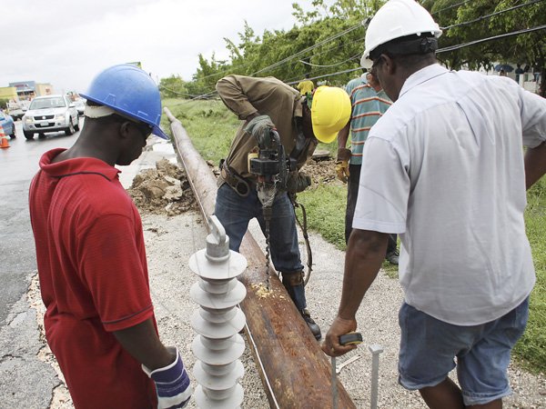 Anthony Minott/Freelance Photographer
Workmen from the Jamaica Public Service repair a utility pole that was damaged during the passage of Hurricane Sandy in Portmore, St Catherine last Thursday.