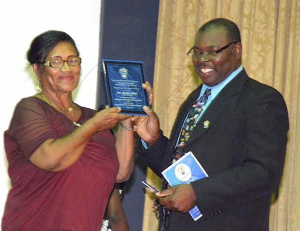 Colin Hamilton/freelance photographer
Golf lecturer Mrs. Gradle Grant receives an award from Dr. Neville Graham for her contribution to the 2008/2009 staging of the UTECH Knights Golf Classic during UTECH Annual Sports Awards Ceremony at the Alfred?Sangster Auditorium on Thursday February 11, 2010.