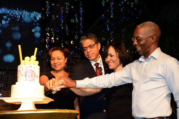 Winston Sill/Freelance Photographer
PUBLIC AFFAIRS DESK:----- President and CEO of Victoria Mutual Building Society Richard Powell (second left) cuts the anniversary cake with (from left) Keri-Gaye Brown, senior vice-president, group legal and corporate secretary; Vivienne Bayley-Hay, vice-president, group marketing and corporate affairs; and Peter Reid, senior vice-president and chief operating officer. VMBS hosted an Anniversary Reception, held at The East Lawn, Devon House, Hope Road on Friday night November 14, 2014.