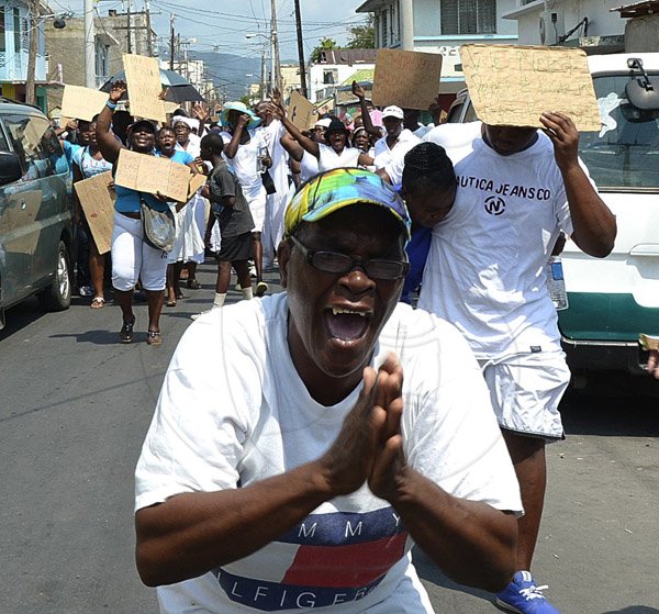 Ian Allen/Photographer
This woman gets into the spirit during the prayer walk through West Kingston on Wednesday.