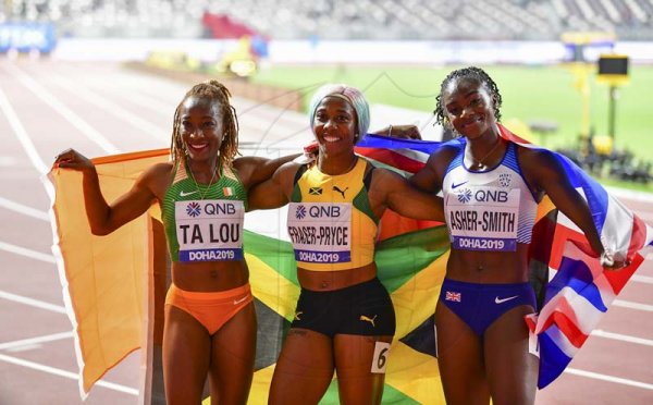 Newly crowned world champion Shelly-Ann Fraser-Pryce (center) celebrates her win along with silver medalist Dina Asher-Smith and Bronze medalist Marie Josep Ta Lou at the 2019 IAAF World Athletic Championships held at the Khalifa International Stadium in Doha, Qatar on Sunday September 29, 2019.